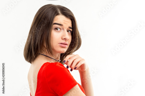 Portrait of a young brunette girl in red t-shirt looking suspiciously over her s Poster