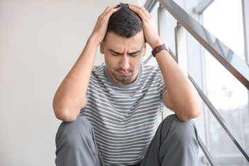 Canvas Print - Unhappy young man sitting on stairs