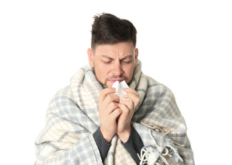 Wall Mural - Man wrapped in blanket suffering from cold on white background