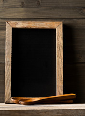 Wall Mural - Wooden kitchen cooking tools with menu board in front of rustic wooden board background