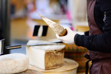 Seller Cutting Organic Cheese On Farmer Market In Strasbourg, France