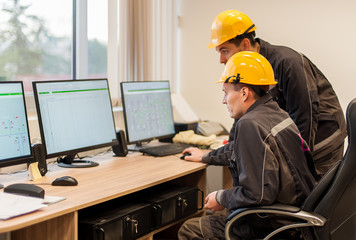 field service engineers inspect relay protection system with laptop computer