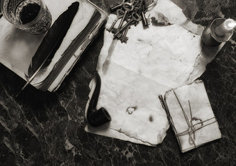 aged retro papers and book on table with detective tools backgro