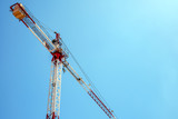Fototapeta  - crane during construction of a new building on blue sky