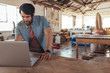 © mavoimages - Craftsman working online with a laptop in his woodworking shop
