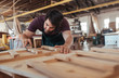 © mavoimages - Woodworker skillfully sanding pieces of wood in his workshop