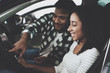 © freeograph - African american family at car dealership. Mother and father are sitting in new car.