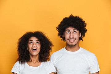 Wall Mural - Portrait of a joyful young afro american couple looking up