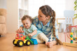 © Oksana Kuzmina - Little child boy and mom playing on the floor with tractor toy