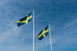 Two Swedish flags on a clear blue sky with slight clouds on a sunny day, Flag of Sweden