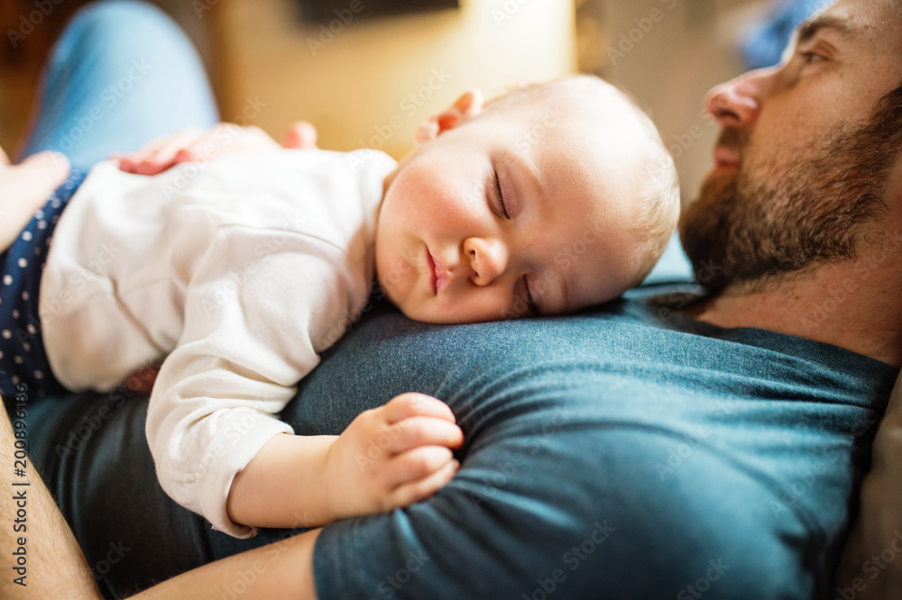 Father with a baby girl at home sleeping. - obrazy, fototapety, plakaty 