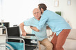 © Africa Studio - Young caregiver helping senior man to sit in wheelchair at home