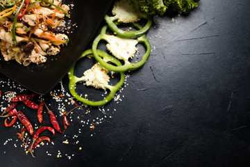 Wall Mural - oriental cuisine meal salad and vegetable on dark background. wholesome healthy food eating. copy space concept