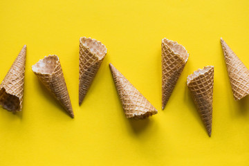 Wall Mural - Empty waffle wafer ice cream cone on a bright yellow background