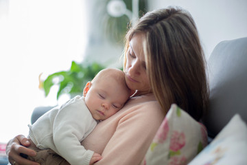 Poster - Young mother, holding tenderly her newborn baby boy