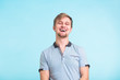 © satura_ - Portrait of happy handsome man laughing on blue background