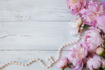 Wall Mural - Pink peonies and roses on a wooden background