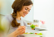 © Alliance - Young woman eating fresh salad in modern kitchen