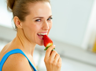 Wall Mural - happy young woman eating strawberry