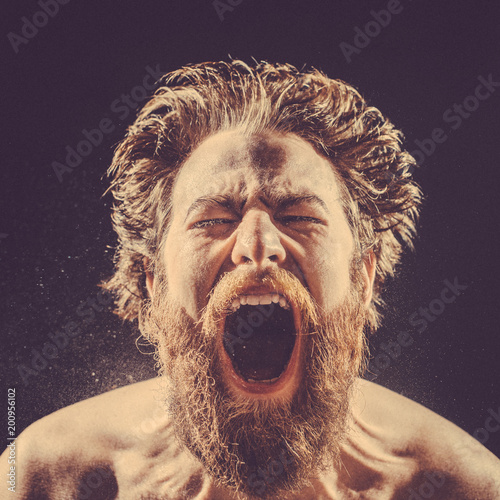 Cuadros en Lienzo A bearded man angrily screams into a spray of water against a black background