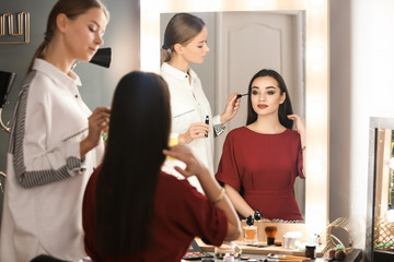 Poster - Professional visage artist applying makeup on woman's face in salon