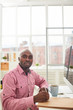 © pressmaster - Portrait of African businessman sitting at his workplace and working