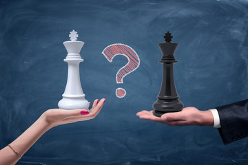 Wall Mural - A chalk question mark between a female hand with a white chess king and a male hand with a black king.