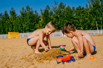 two boys playing in the sand