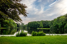 Blue Sky Over A Lake And Green Grass At Haagse Bos, Forest In The Hague
