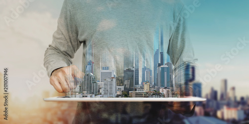 Fotografía a man using digital tablet, and modern buildings hologram