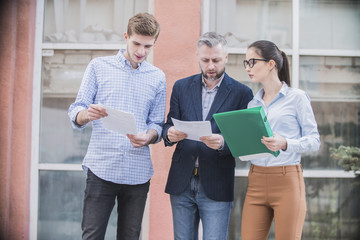 Wall Mural - 
a group of businessmen discussing business plans on the street
