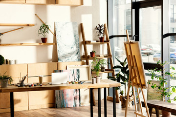 interior of artist studio with painting supplies and laptop on table