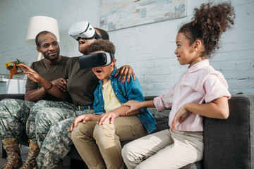 Wall Mural - African American female and male soldiers and their children using Virtual reality headsets