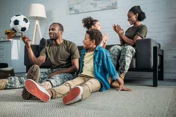 Wall Mural - Army soldiers with happy kids playing at home