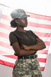 © LIGHTFIELD STUDIOS - Young african american female soldier in camouflage clothes in front of us flag