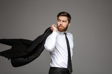 Wall Mural - Portrait of a confident young businessman posing with jacket