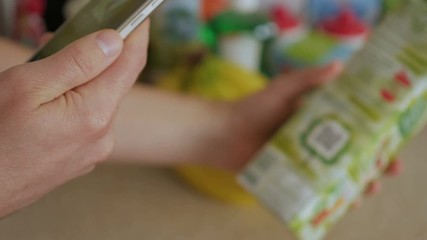 A man scans the QR code on a check on a juice box from a supermarket.