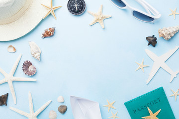 Summer holidays, vacation, travel and tourism frame from sunglasses, hat, passport, airplane and boat miniatures, starfish. Top view. Flat lay.