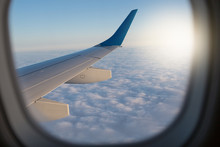View Through The Airplane Window, Window Frame, Above The Clouds, Visible Part Of The Wing And Clouds, Concept Travel