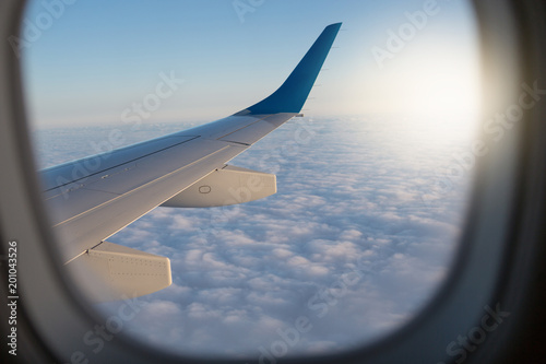Fotografie, Obraz view through the airplane window, window frame, above the clouds, visible part o