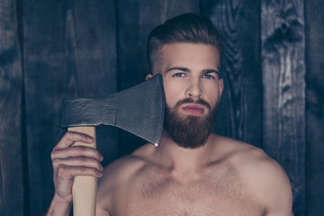 Barber shop barbershop. Close up portrait of sexy handsome naked manly serious concentrated confident attractive stylish logger feller trying to shave beard using axe isolated gray wooden background