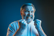 The senior emotional angry man screaming on blue studio background