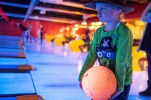 Little Funny Boy In A Hat Playing Bowling, Blurred Motion