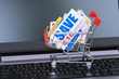 Saving discount coupon voucher in shopping cart and computer notebook, coupons are mock-up