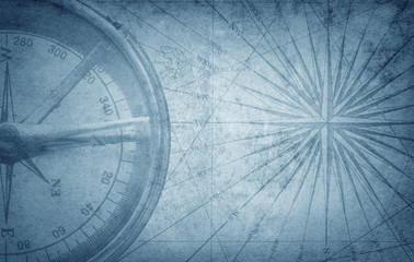 Old vintage retro compass on ancient map. Survival, exploration and nautical theme grunge background