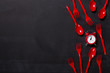 Top view on plastic forks and clock on black background