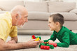 © Prostock-studio - Boy playing with grandfather in building kit