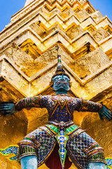 Statue of demon holding up the Golden chedi at the Wat Phra Kaew Palace, also known as the Emerald Buddha Temple. Bangkok, Thailand.