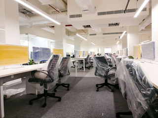 colorful new office with cubicles, chairs, tables and carpets. The plastic polythene covers are still on the chairs and tables