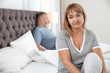 © New Africa - Mature couple with problem in relationship on bed at home